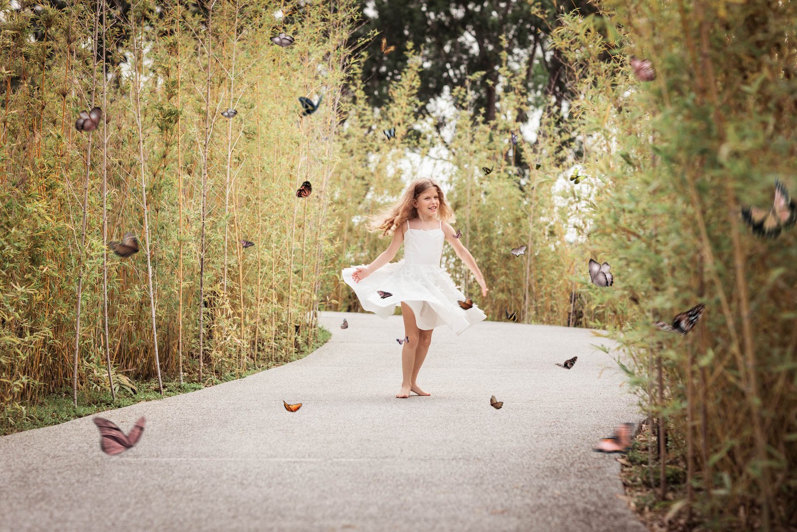 fotografía de una niña bailando con mariposas