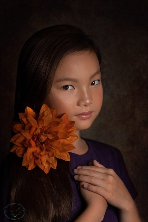 niña con flor naranja